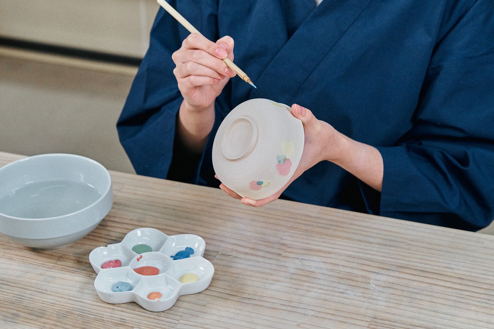 器に絵付けをする手元